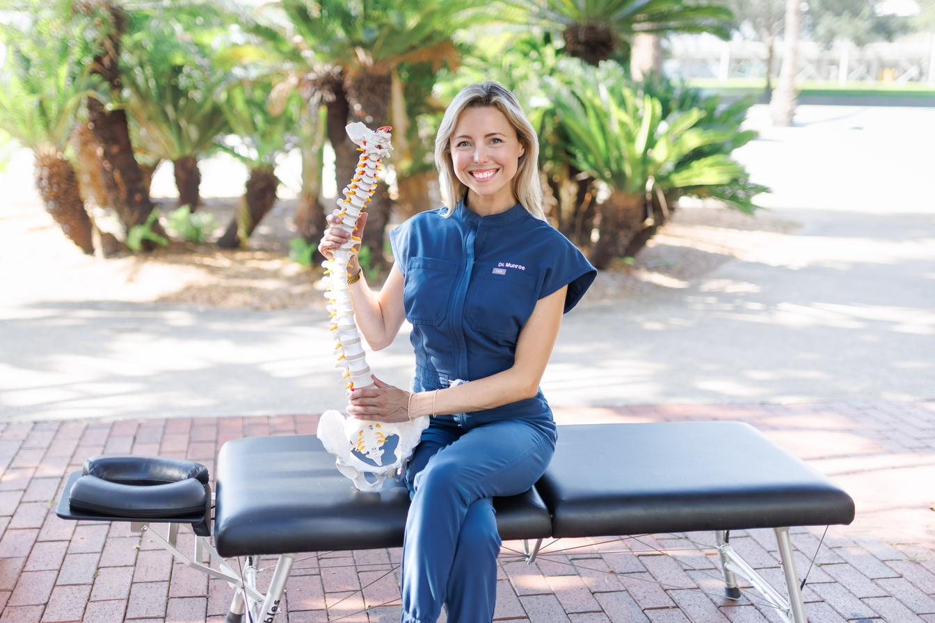 Dr. Ann Munroe, DC, holding a spine model, certified SoftWave TRT provider in St. Petersburg, FL